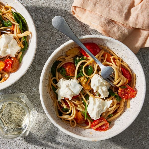 Overhead view of two stone bowls of Burrata Pasta with Cherry Tomatoes & Spinach recipe Credit: Photographer: Jen Causey, Food Stylist: Emily Nabors Hall, Prop Stylist: Josh Hoggle