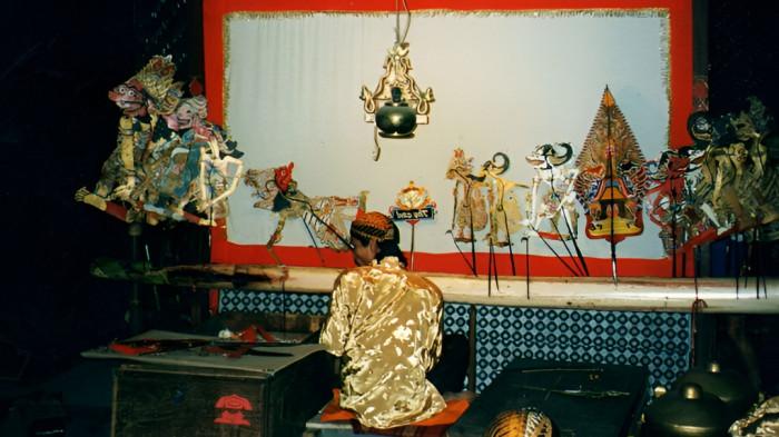 WAYANG KULIT- Seorang dalang sedang bersiap memainkan wayang kulit dengan narasi atau cerita tentang kisah tokoh pewayangan.