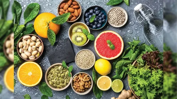 Flat lay of vibrant citrus fruits, mixed nuts, seeds, fresh blueberries, and green leafy vegetables for nutrition.