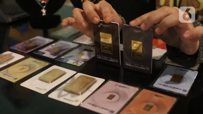 Karyawan menunjukkan kepingan emas yang dijual di Galeri 24, Jakarta, Selasa (15/12/2020). Harga emas hasil produksi PT Aneka Tambang Tbk (Antam) atau emas Antam kini turun Rp 1.000 per gram menjadi Rp 951 per gram pada perdagangan, Selasa (15/12). (Liputan6.com/Angga Yuniar)